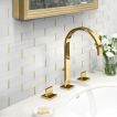 Powder room backsplash featuring Love of Brass metal mosaic tile in polished White Whisp Dolomiti marble with Brass accents.