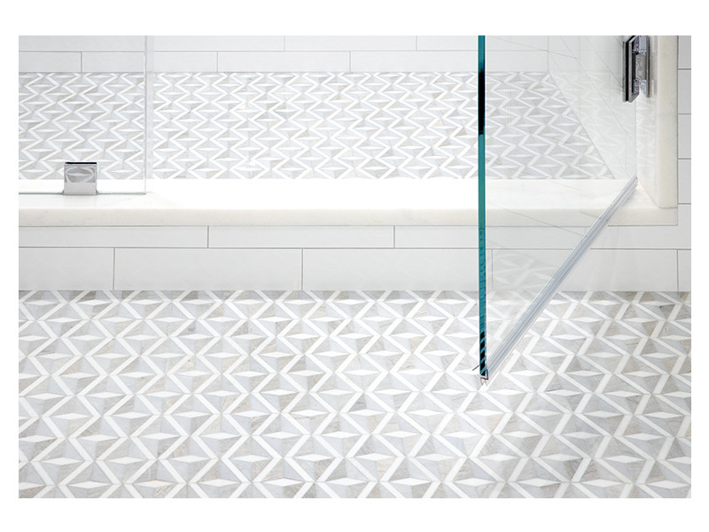 A close up of the Diamondelle marble mosaic on the floor of this primary bathroom design.