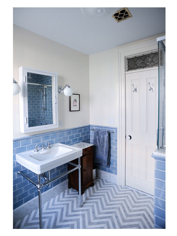 The floor of this primary bathroom design by Hatheway Architects is a custom chevron pattern made from Thassos and Carrara marble.