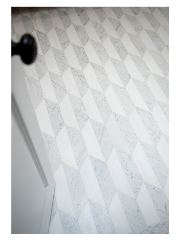 A detailed shot of the master bathroom floor, featuring the Art of Deco Chrysler Spire Solid pattern, made from White Whisp Dolomiti and Carrara Claro Light honed marble.